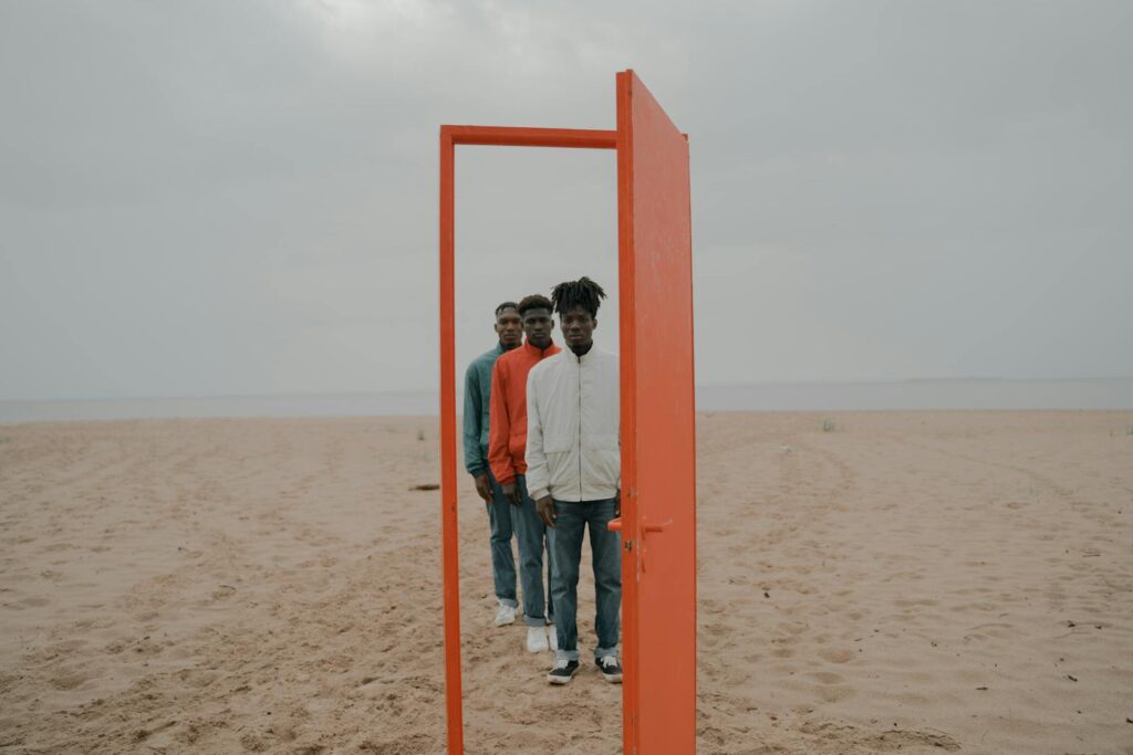 Best way to schedule a meeting with multiple attendees 61 Conceptual image of three men through a red door on a beach.